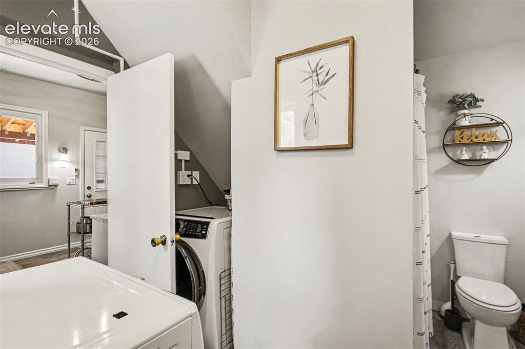 Image 13 of 36: Remodeled master bathroom with laundry