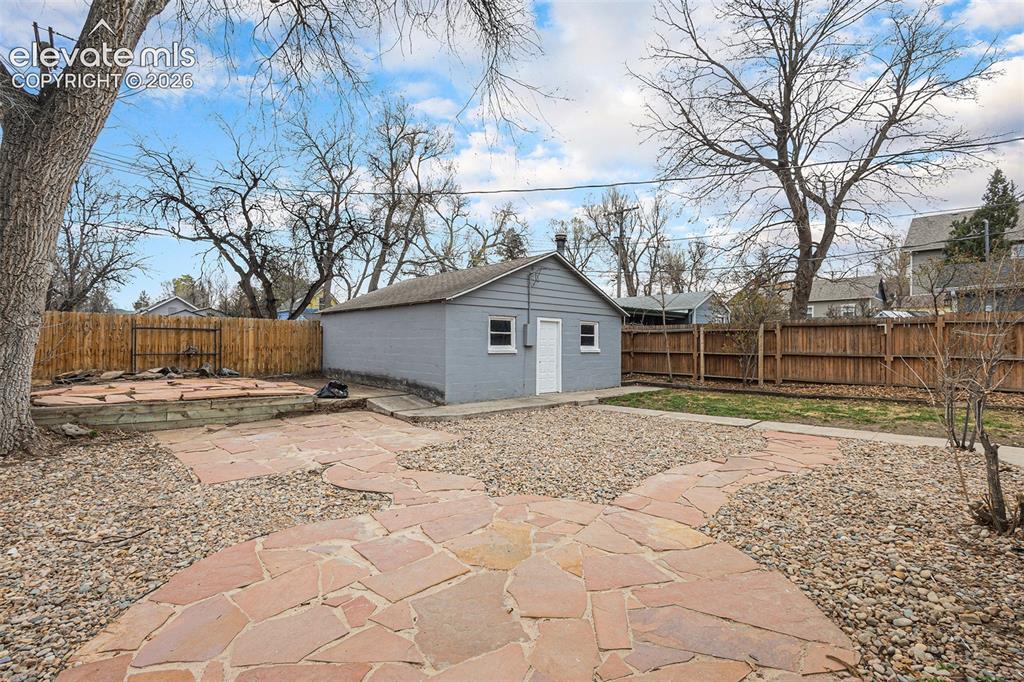 Image 29 of 36: Beautifully, low maintenance xeriscaping in back yard with alley access to