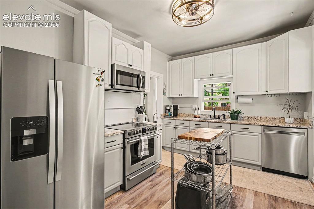 Image 7 of 36: Updated kitchen with stainless steel appliances and granite counters