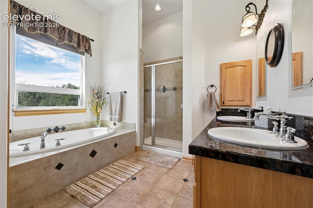 Image 19 of 48: Primary suite bathroom - jetted tub with mountain views.