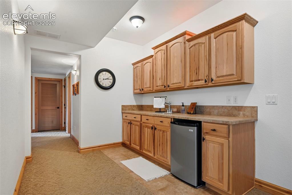 Image 24 of 48: Wet bar with mini fridge that conveys