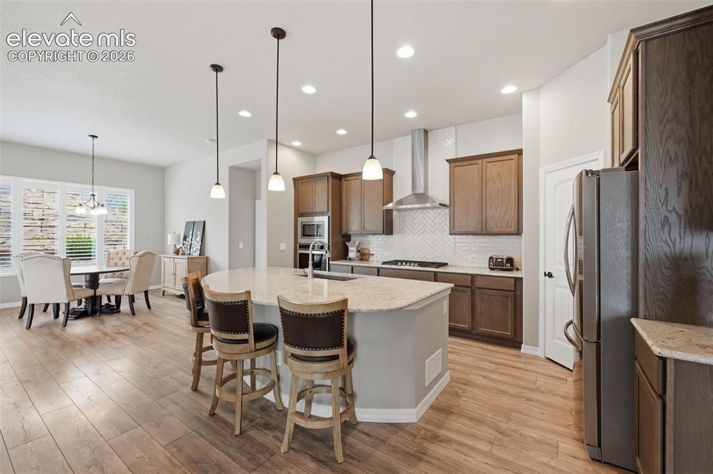 Image 10 of 33: Incredible kitchen with stainless steel hood and tile backsplash with gas r