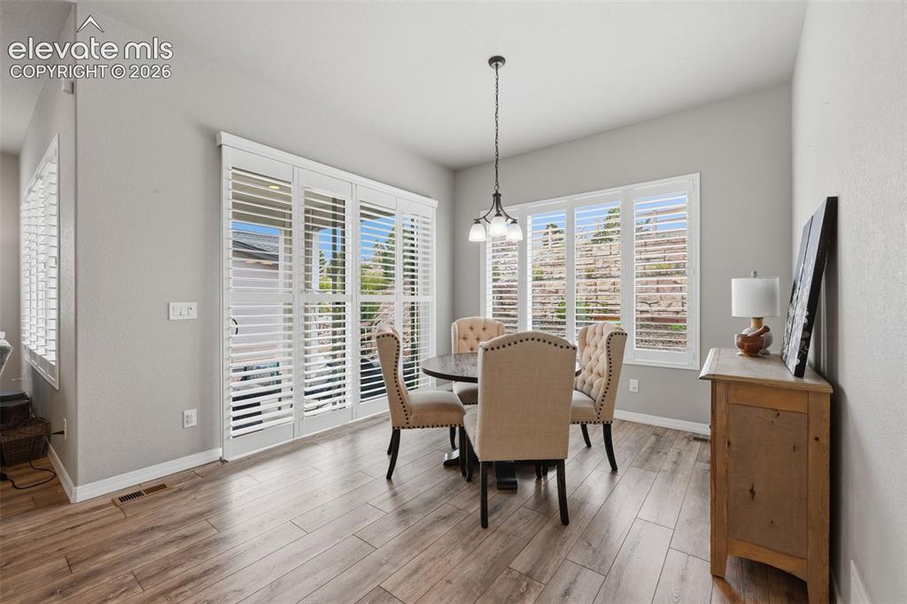 Image 13 of 33: Spacious breakfast nook with plantation shutters and walk out to covered pa