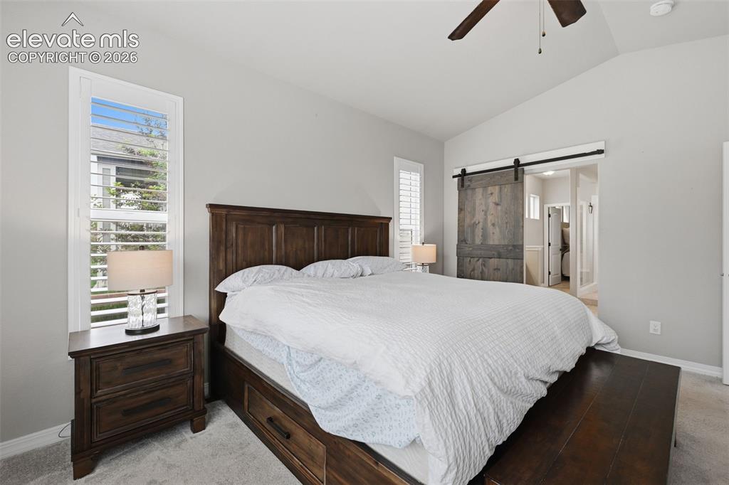 Image 14 of 33: Main level private master retreat with vaulted ceiling, plantation shutters