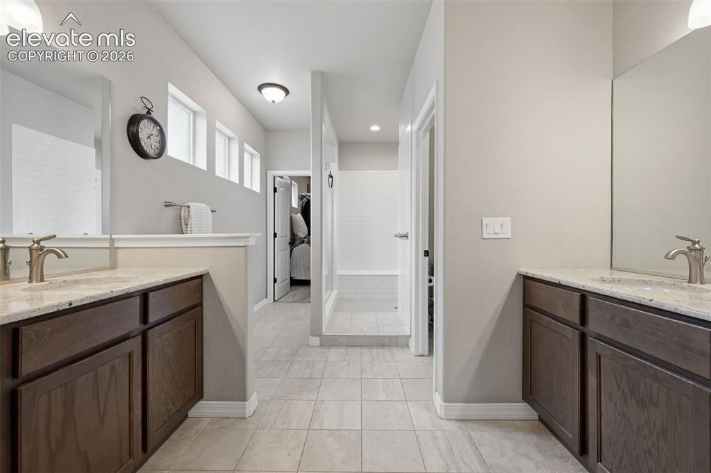 Image 16 of 33: Spa like master bath with huge walk in shower, two sinks and granite counte