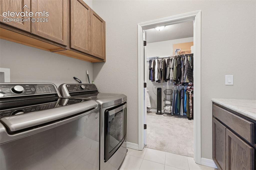Image 19 of 33: The master bath closet walks through tot he laundry room!  Barn door on the