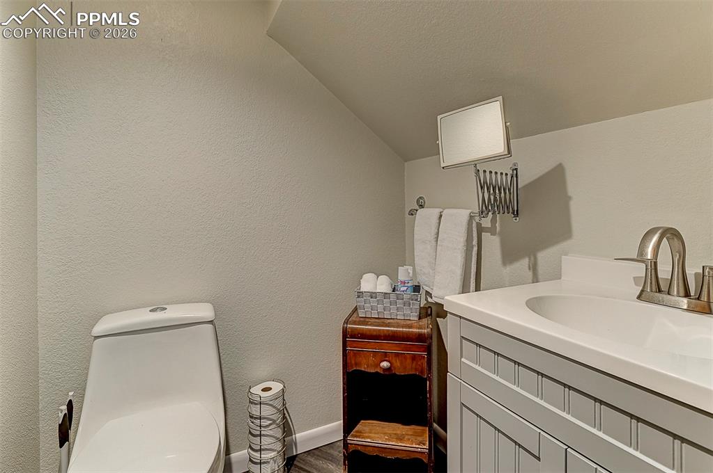 Image 11 of 41: Powder bathroom featuring LVP floors and lofted ceiling