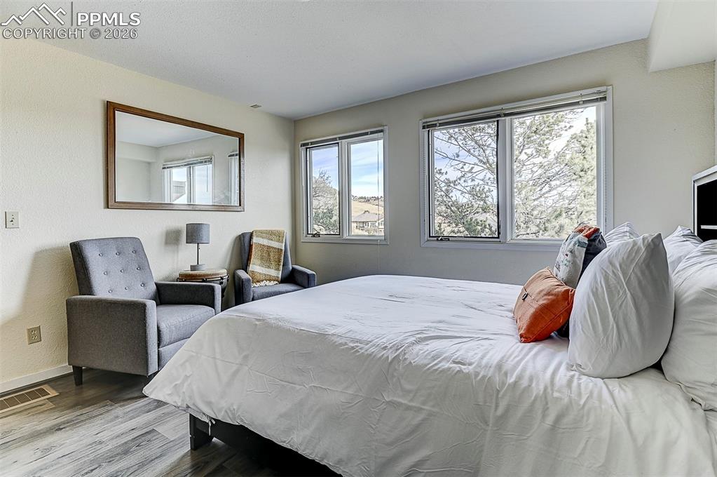Image 27 of 41: Bedroom featuring wood finished floors and baseboard heater.