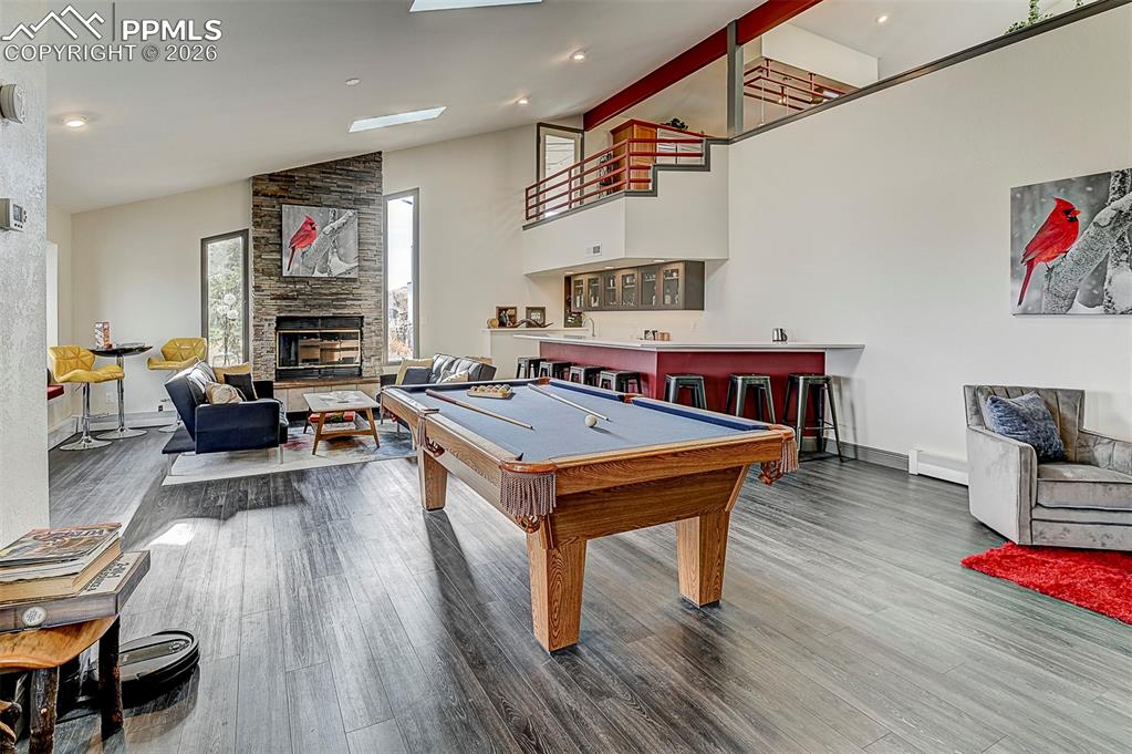 Image 6 of 41: Playroom featuring a stone fireplace, pool table, a baseboard heating unit,