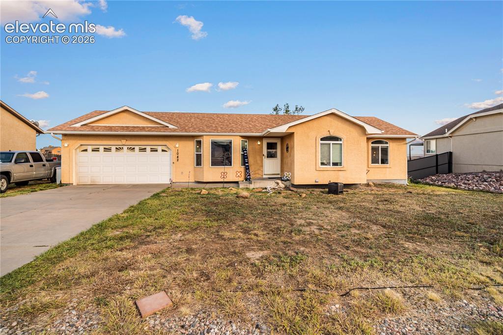 Image 1 of 20: Single-story exterior with an attached garage, paved driveway, and multiple
