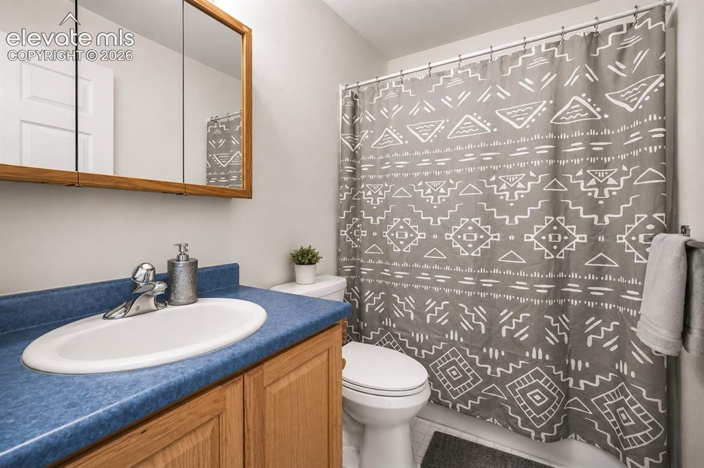 Image 11 of 20: Bathroom featuring a wood vanity with a blue laminate countertop, integrate
