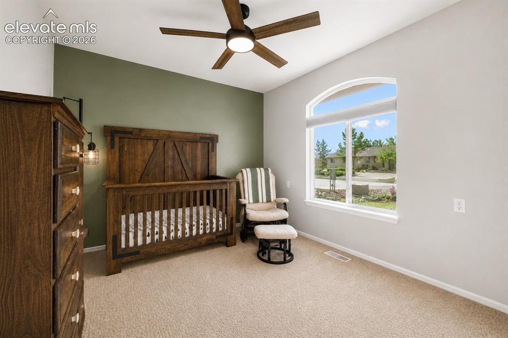 Image 12 of 20: Carpeted room featuring an arched picture window, a ceiling fan with integr