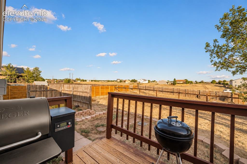 Image 16 of 20: Outdoor wood-finish deck featuring a warm-toned railing and a spacious open