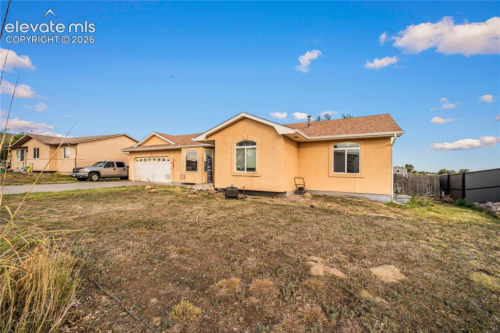 Image 20 of 20: Contemporary stucco exterior with a two-car garage