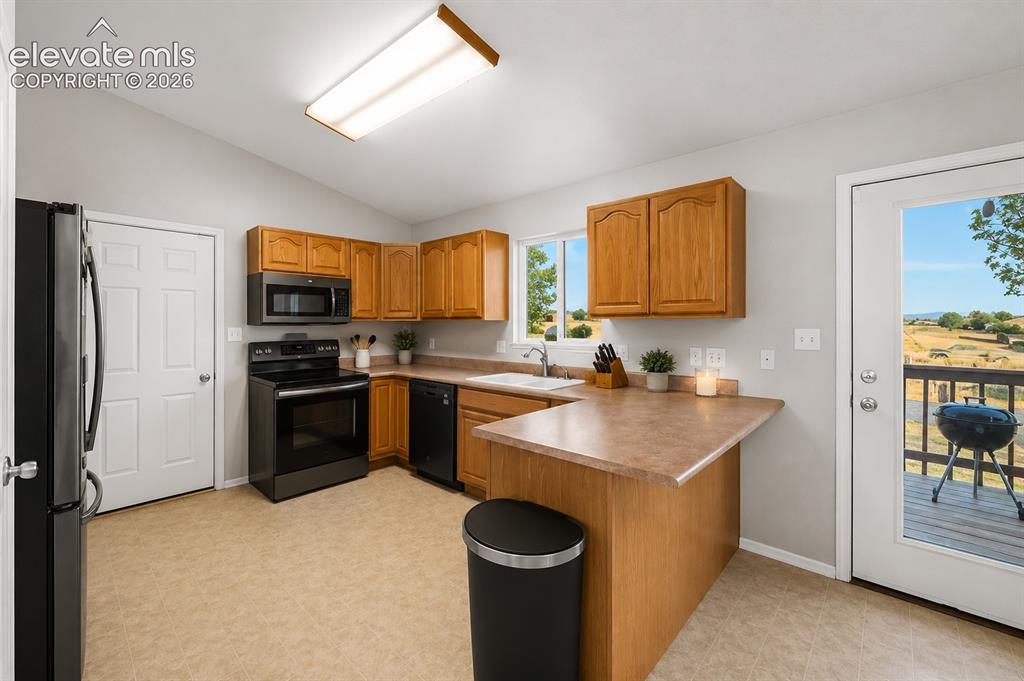 Image 4 of 20: Kitchen featuring wood cabinetry, laminate countertops, a full suite of bla