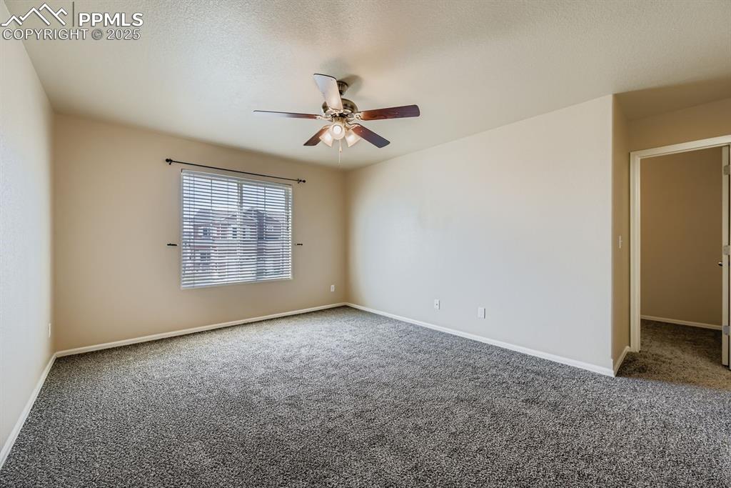 Image 13 of 26: Empty room with carpet flooring, a ceiling fan, and a textured ceiling