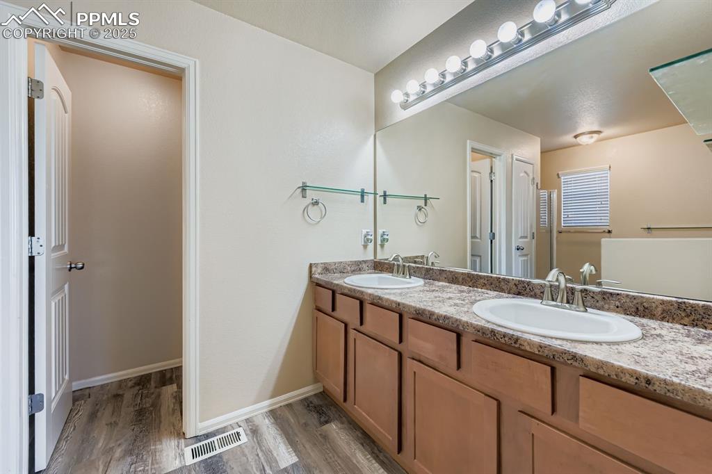 Image 17 of 26: Full bath with light wood-style floors and double vanity