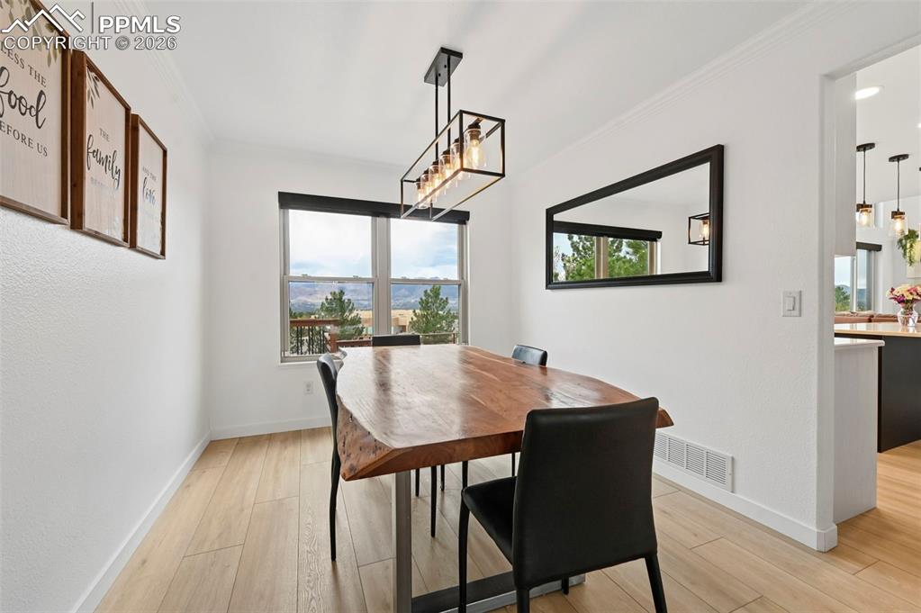 Image 16 of 50: Dining room featuring light wood-style flooring, ornamental molding, and su