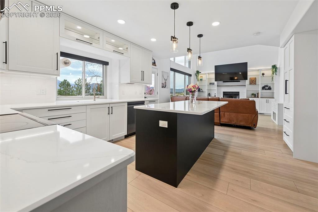 Image 17 of 50: Kitchen featuring a kitchen island, open floor plan, dual tone cabinetry, h