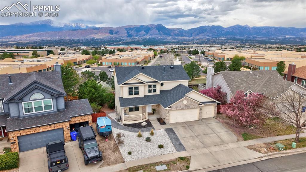 Image 2 of 50: Aerial view of residential area featuring a mountainous background