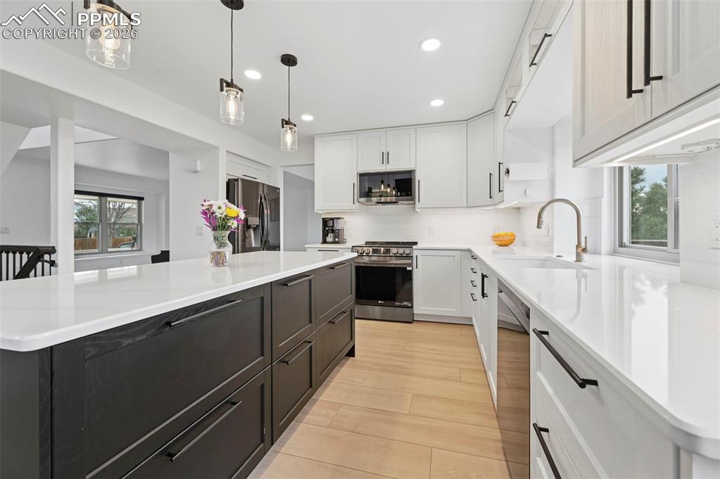 Image 20 of 50: Dual tone kitchen with healthy amount of natural light, dual tone cabinets,