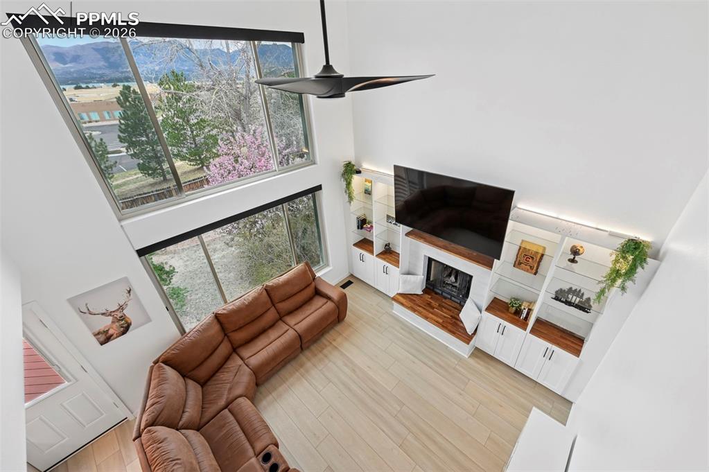 Image 26 of 50: Living area featuring a high ceiling, plenty of natural light, ceiling fan,