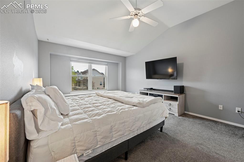 Image 29 of 50: Bedroom with carpet floors, vaulted ceiling, and a ceiling fan