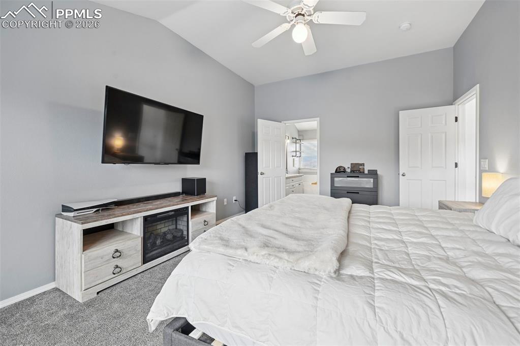 Image 33 of 50: Bedroom featuring light colored carpet, a ceiling fan, lofted ceiling, and 