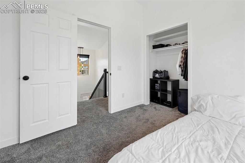 Image 38 of 50: Bedroom with dark carpet and a closet
