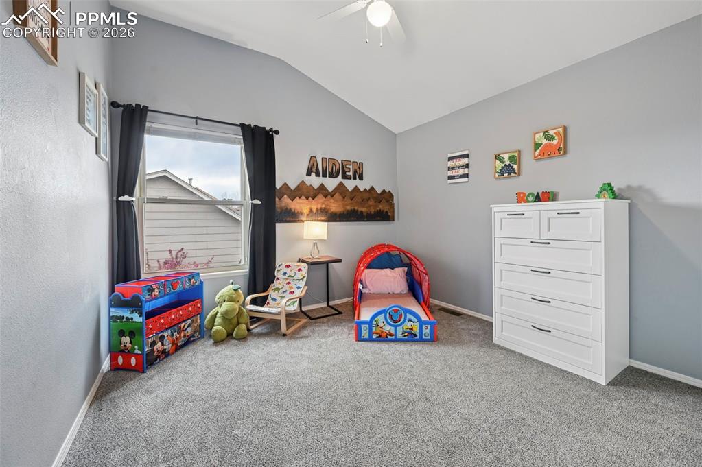 Image 39 of 50: Playroom with lofted ceiling, ceiling fan, and carpet flooring