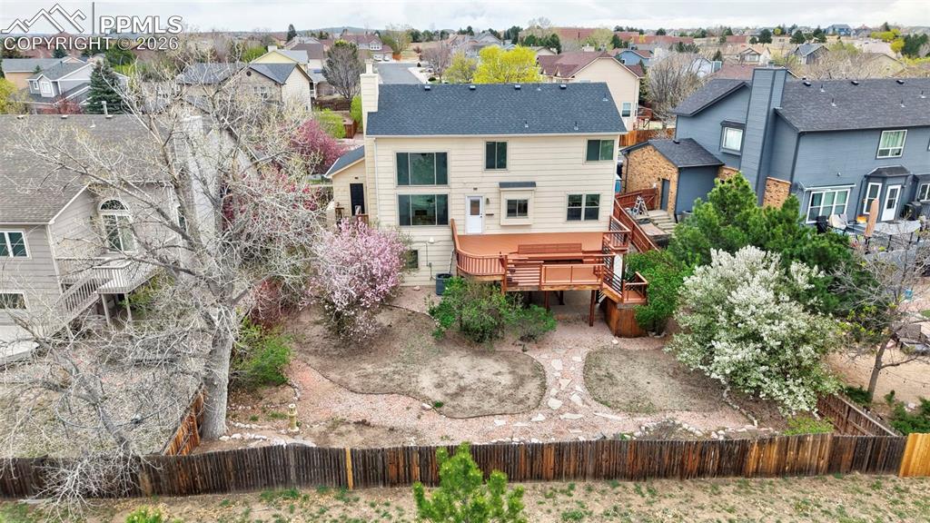Image 8 of 50: Back of house featuring a wooden deck, a residential view, and a chimney
