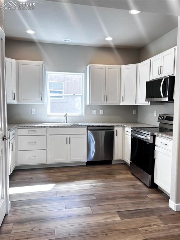 Image 4 of 14: Kitchen with stainless steel appliances, Aristokraft cabinets, LVP flooring