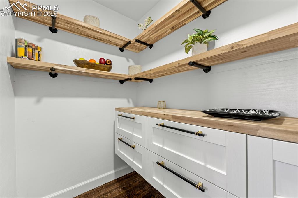 Image 19 of 50: Walk in pantry featuring dark wood finished floors large drawers and lots o