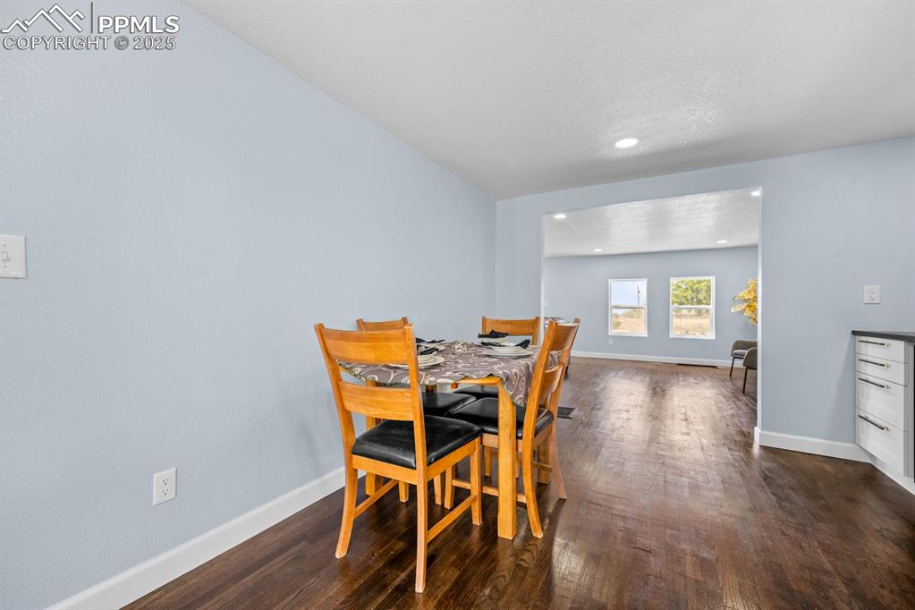 Image 21 of 50: Dining space featuring dark wood-type flooring and recessed lighting with s
