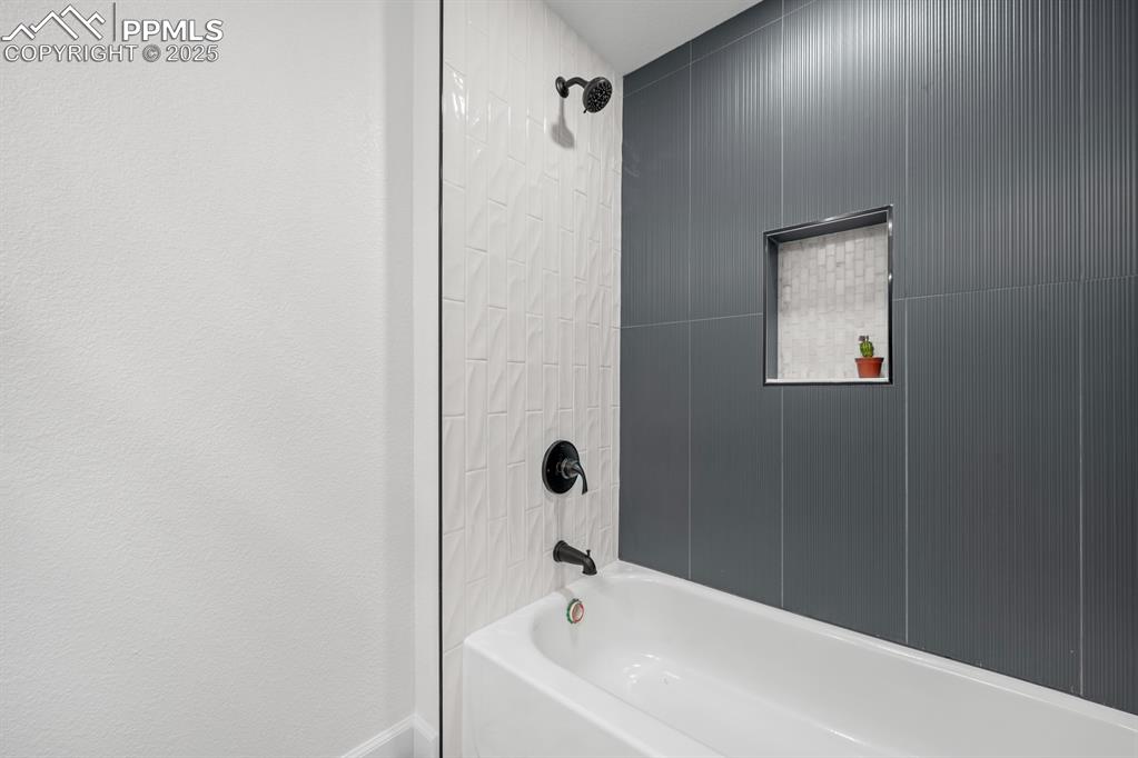 Image 31 of 50: Bathroom with shower / bathtub combination