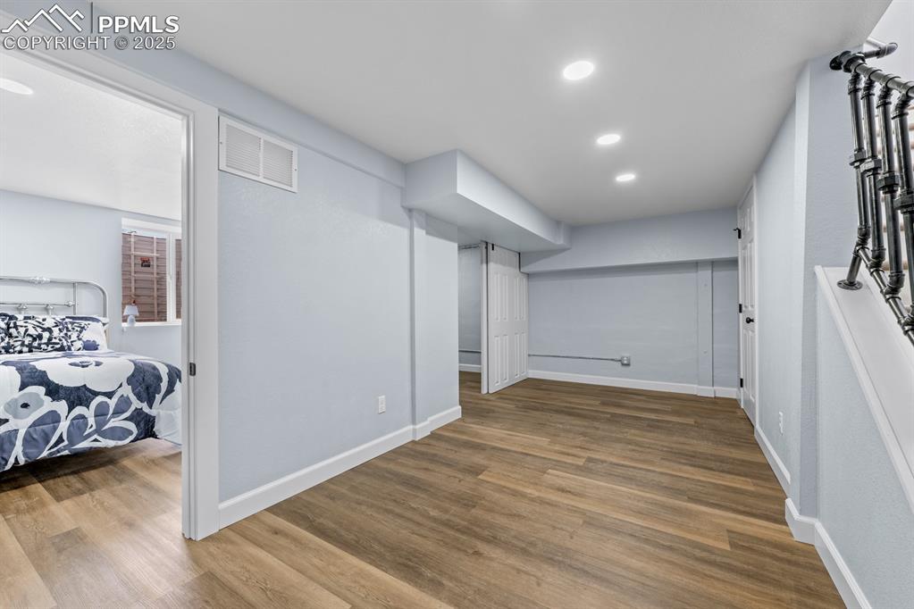 Image 35 of 50: Bedroom with wood finished floors and recessed lighting