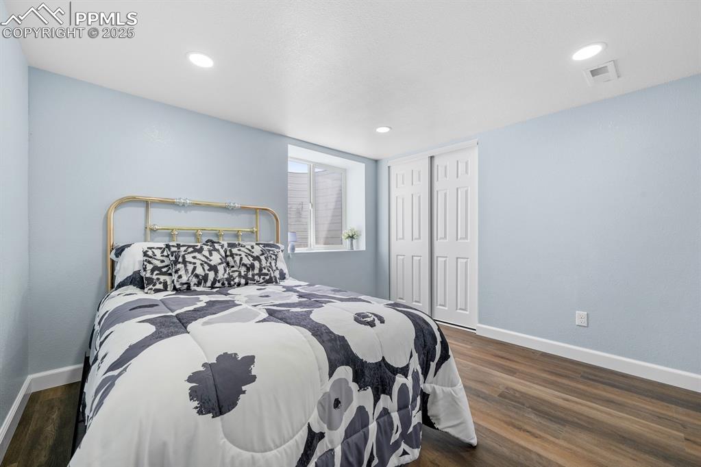 Image 37 of 50: Bedroom with dark wood finished floors, a closet, and recessed lighting