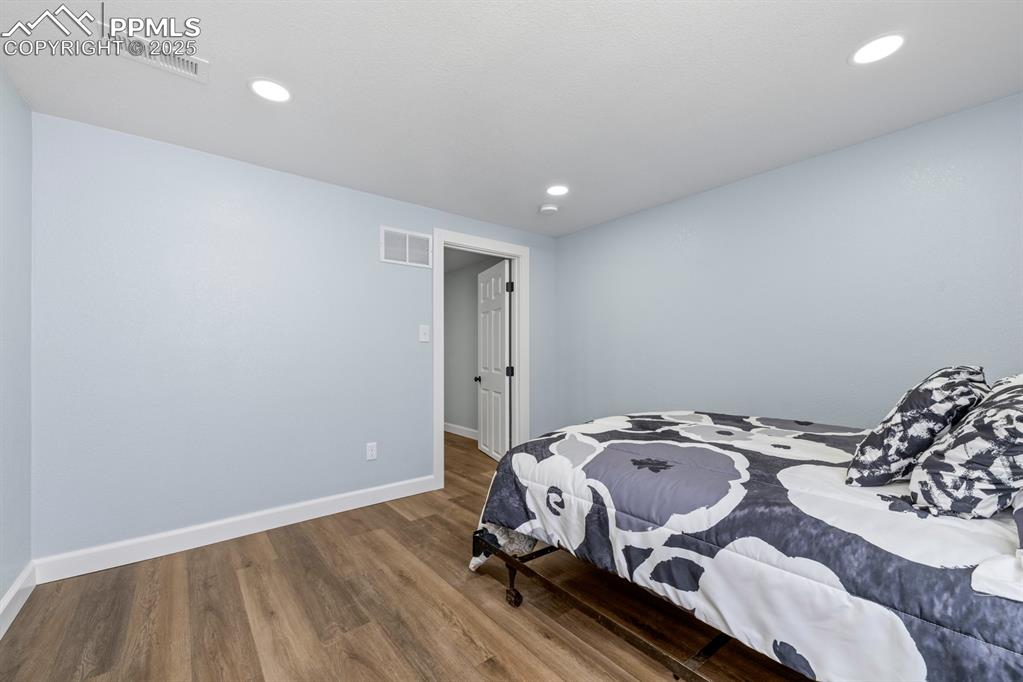 Image 38 of 50: Bedroom with wood finished floors and recessed lighting