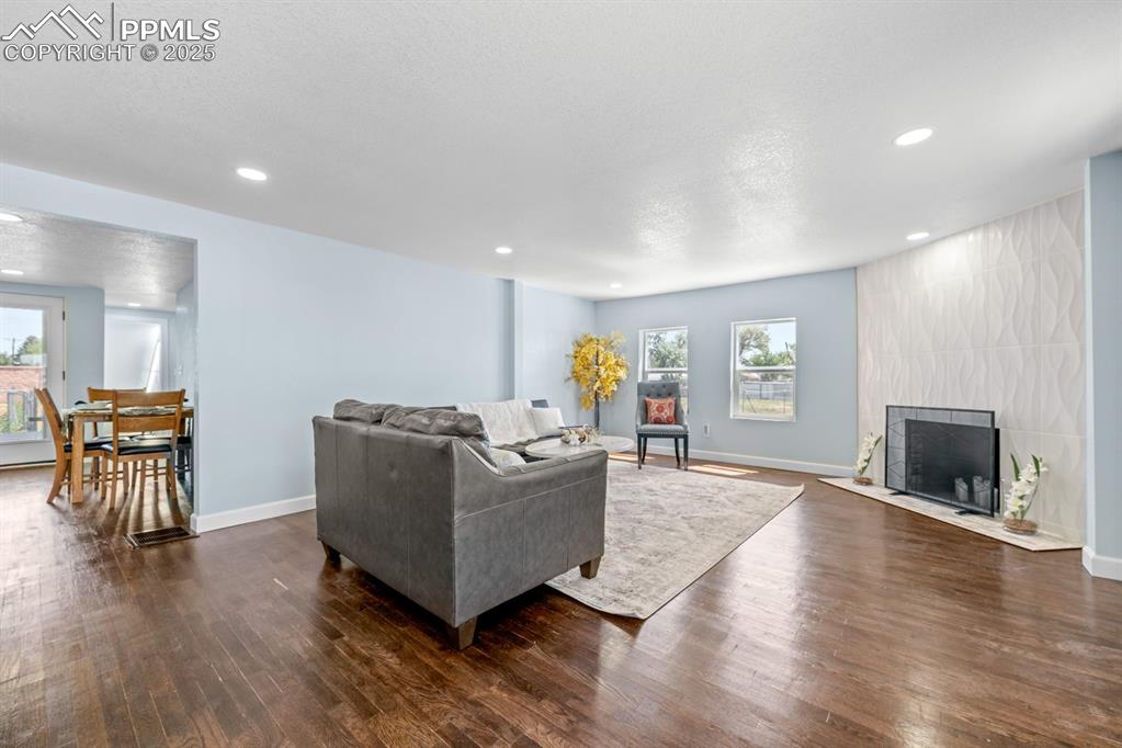 Image 9 of 50: Living room with wood finished floors and recessed lighting