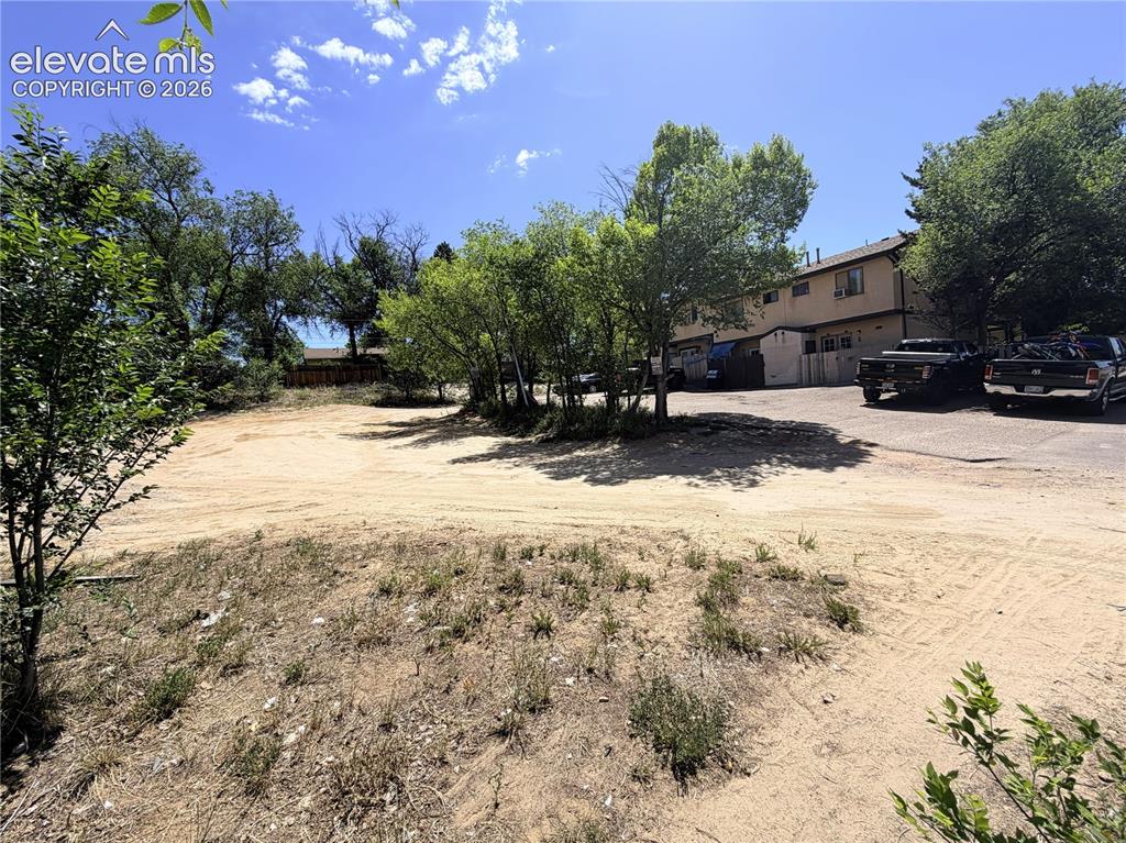 Image 1 of 8: Expansive undeveloped lot featuring mature trees and a clear, level area