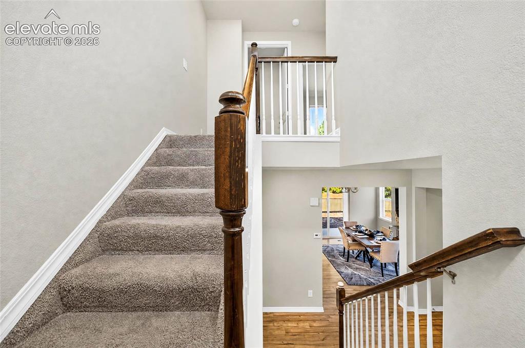 Image 19 of 41: Carpeted staircase with a wood-finish newel post and handrail