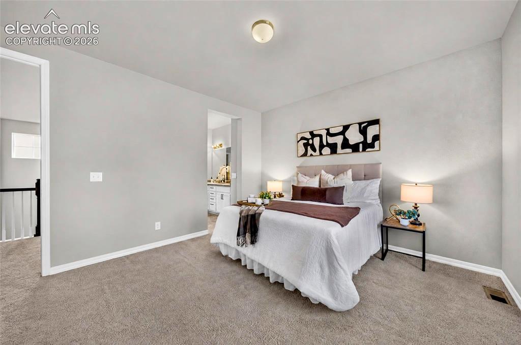 Image 22 of 41: Bedroom with neutral gray walls and carpeted flooring