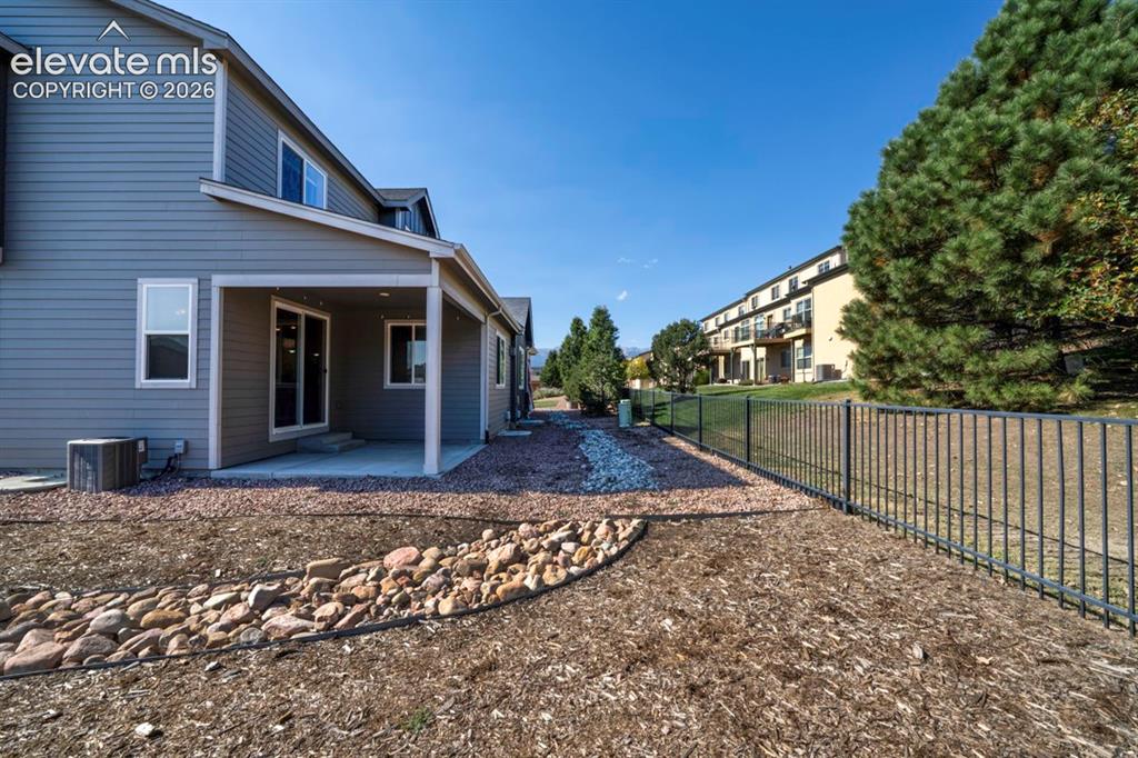 Image 32 of 41: Covered patio with concrete flooring, sliding glass door entry, and two win