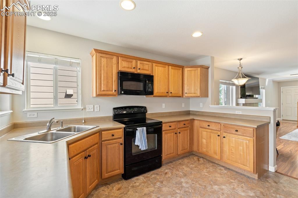 Image 11 of 38: Recessed lighting and corner windows open up the kitchen