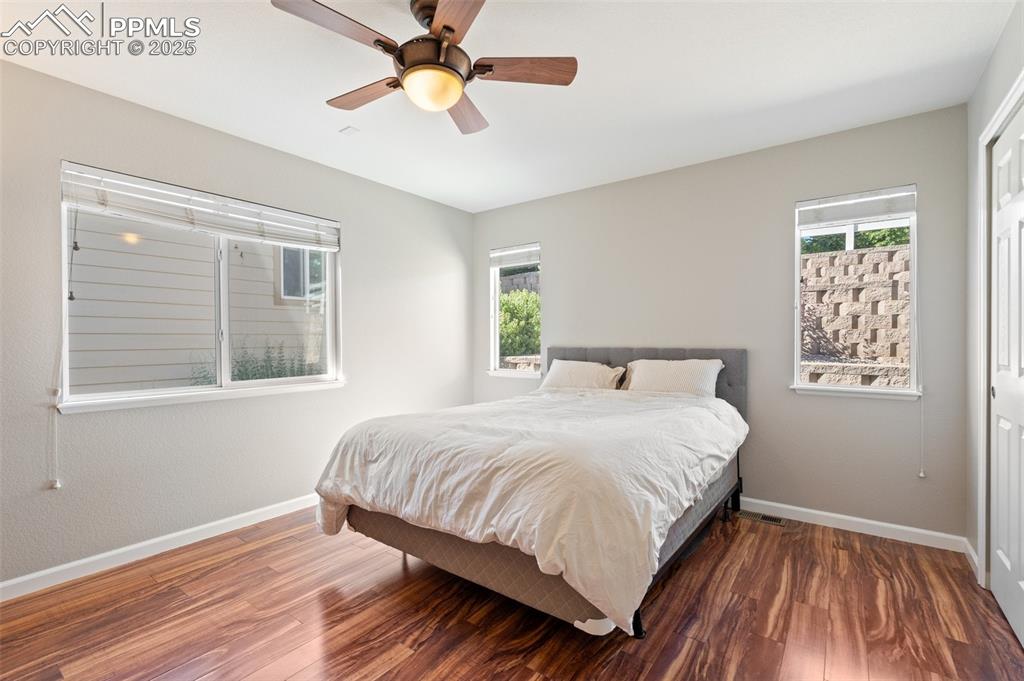 Image 15 of 38: Main level bedroom with large windows