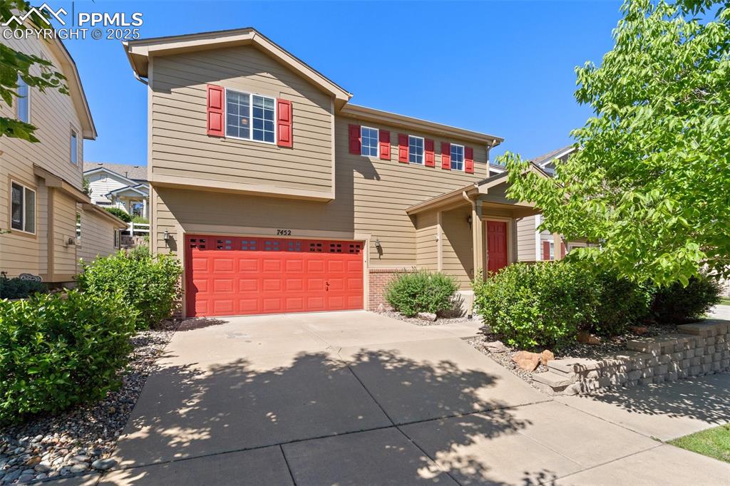 Image 2 of 38: 2 story home with covered front patio and low maintenance landscaping