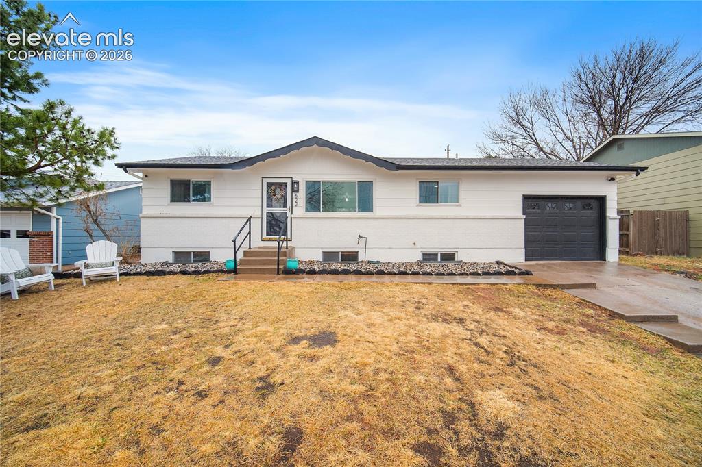 Caption: Ranch-style exterior with white siding, black trim, and an attached single-car garage