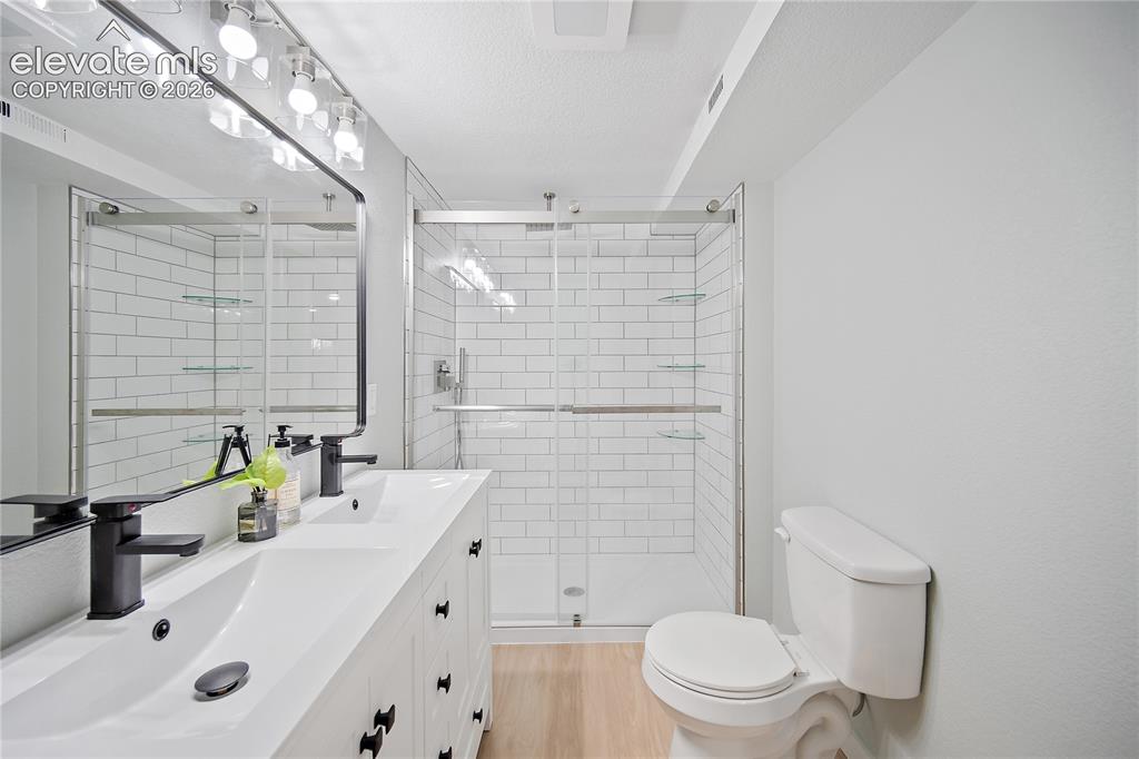 Image 14 of 18: Dual vanity with integrated sinks and matte black fixtures, framed mirror w