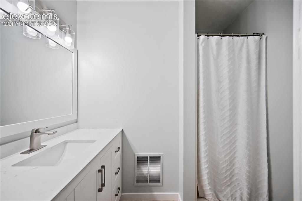 Image 8 of 18: Vanity featuring a single undermount sink, brushed nickel faucet, and white