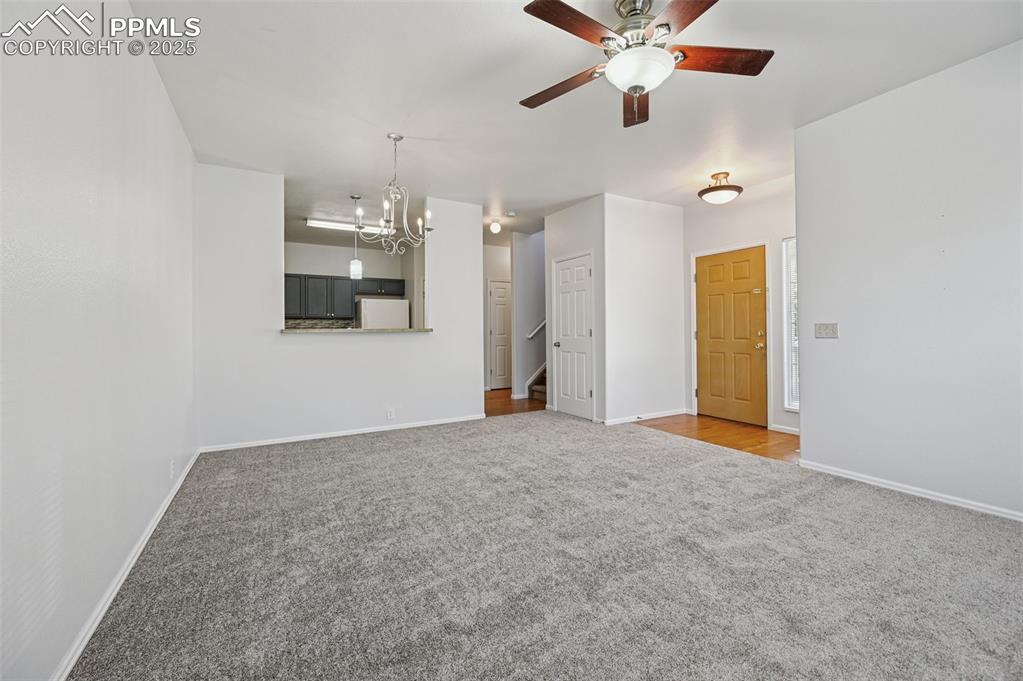 Image 10 of 31: Unfurnished living room with carpet flooring, a chandelier, and a ceiling f